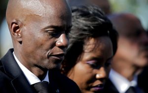 Jovenel and Martine Moïse walk past the camera.